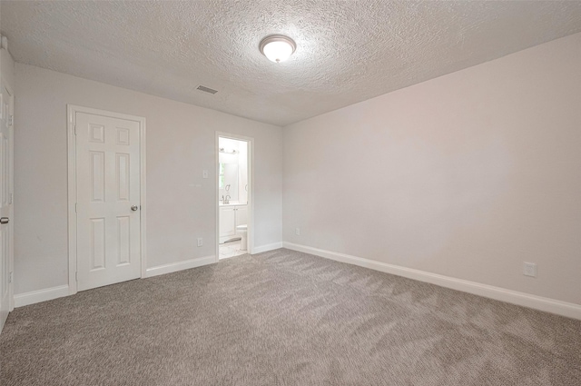 unfurnished room with carpet floors and a textured ceiling