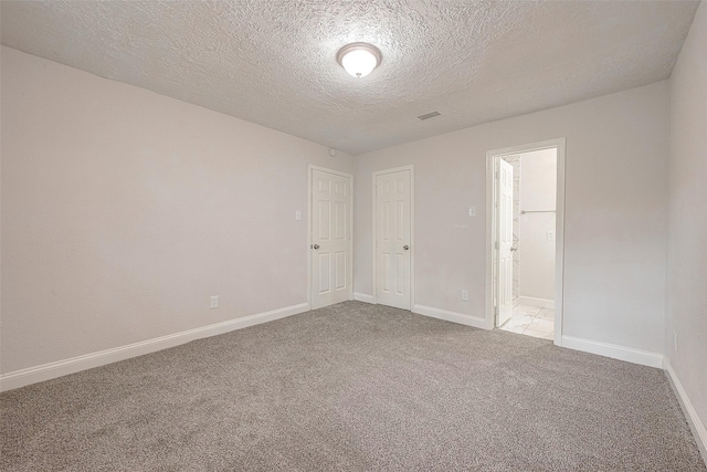 carpeted spare room with a textured ceiling