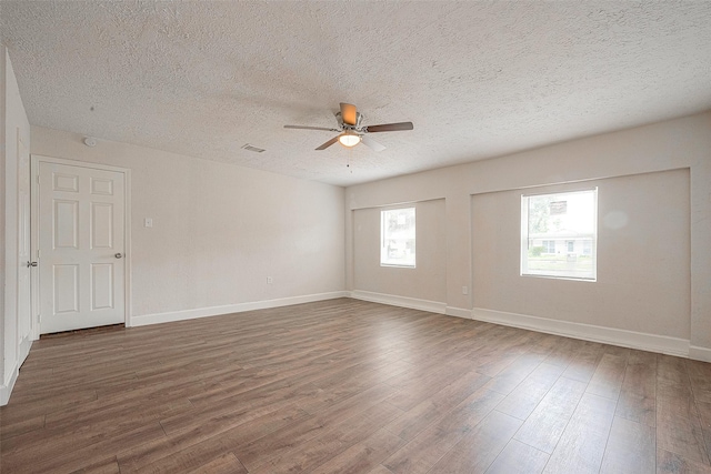 unfurnished room featuring ceiling fan, dark hardwood / wood-style floors, and a textured ceiling