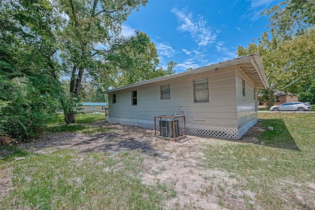 rear view of property featuring cooling unit and a yard