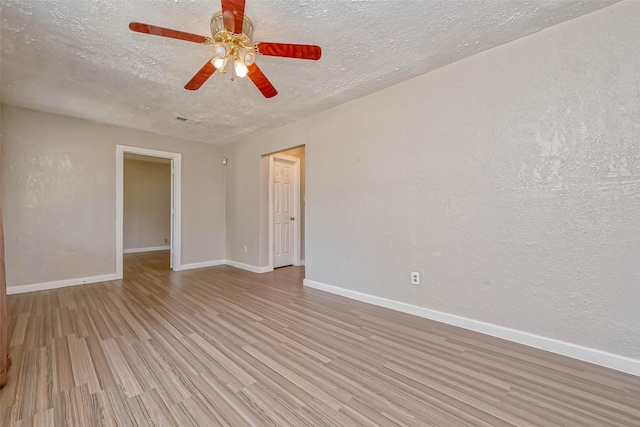 unfurnished room featuring ceiling fan, light hardwood / wood-style floors, and a textured ceiling