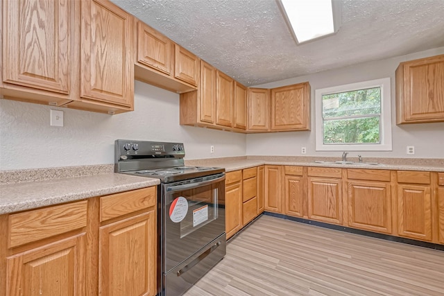 kitchen with a textured ceiling, sink, black range with electric cooktop, and light hardwood / wood-style flooring