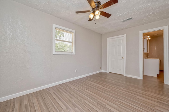 unfurnished room featuring a textured ceiling, hardwood / wood-style flooring, and ceiling fan