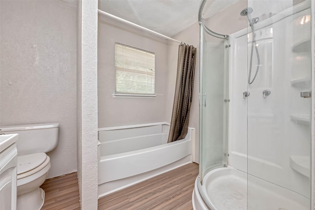 bathroom with walk in shower, vanity, a textured ceiling, wood-type flooring, and toilet