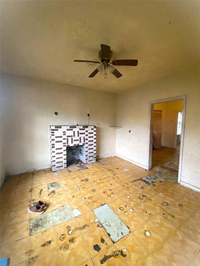 unfurnished living room featuring ceiling fan and a fireplace