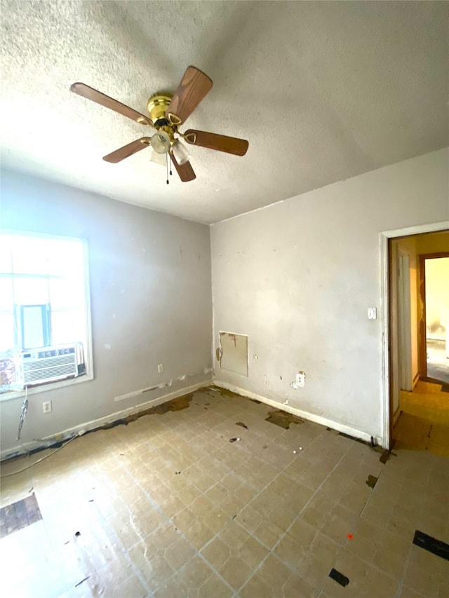 empty room with ceiling fan, cooling unit, and a textured ceiling