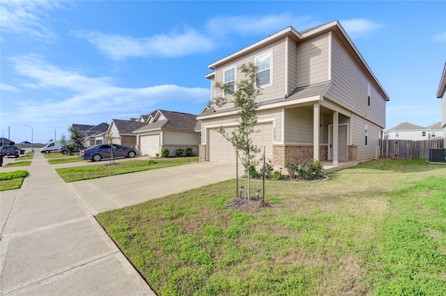 view of front of house with central air condition unit, a front lawn, and a garage