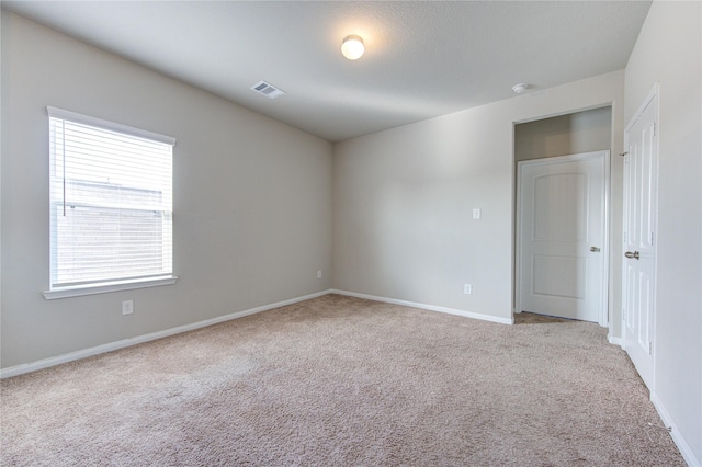 unfurnished room featuring light carpet and plenty of natural light