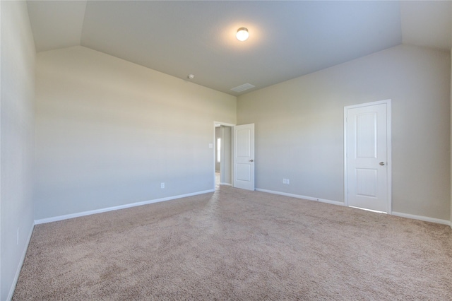 carpeted empty room featuring lofted ceiling