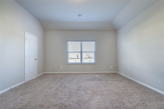 empty room featuring light carpet and lofted ceiling