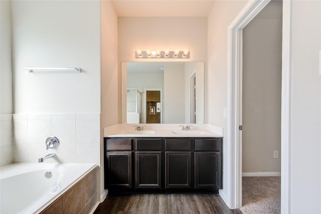 bathroom featuring vanity and tiled tub