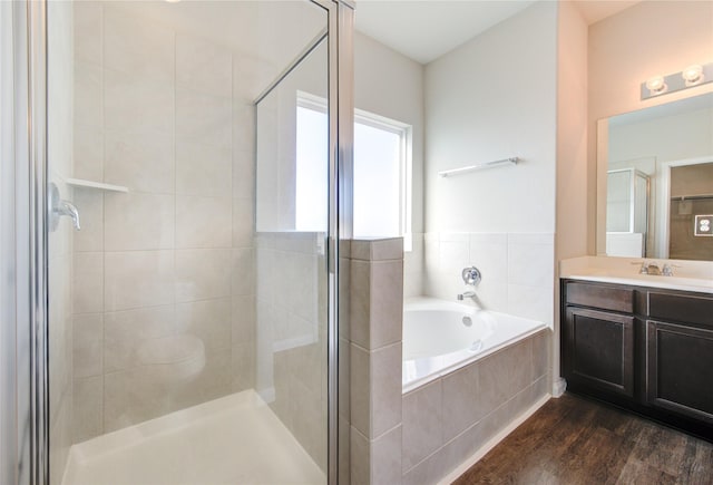 bathroom featuring vanity, wood-type flooring, and plus walk in shower