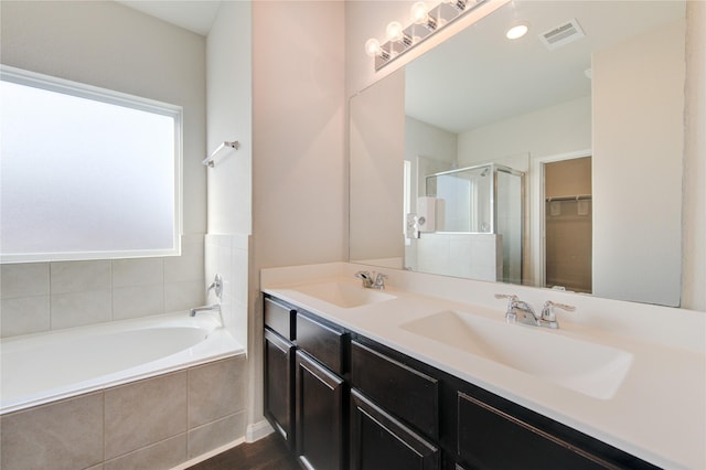 bathroom featuring hardwood / wood-style flooring, vanity, and shower with separate bathtub