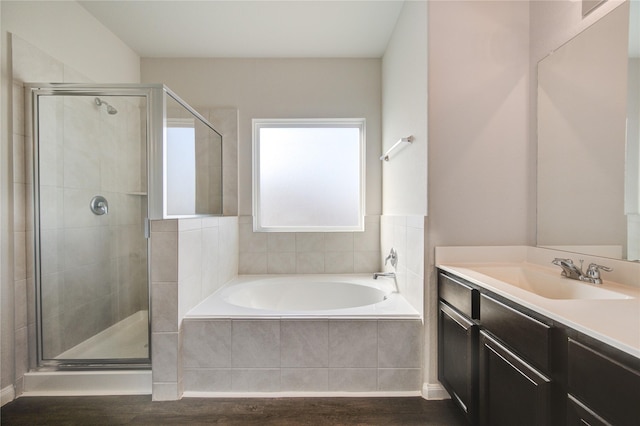 bathroom featuring vanity, wood-type flooring, and plus walk in shower