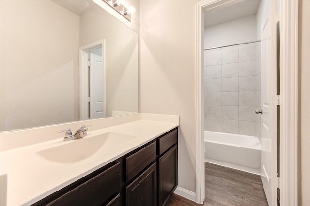 bathroom featuring hardwood / wood-style flooring, vanity, and tiled shower / bath