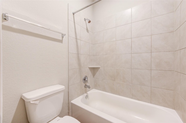 bathroom featuring tiled shower / bath and toilet