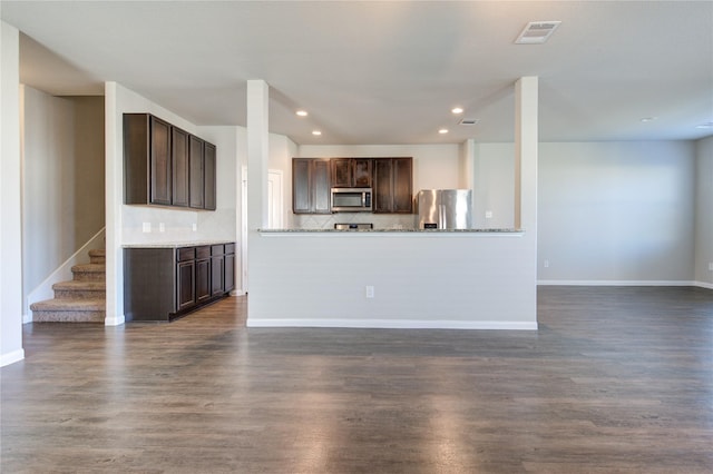 kitchen featuring dark hardwood / wood-style flooring, dark brown cabinetry, and appliances with stainless steel finishes