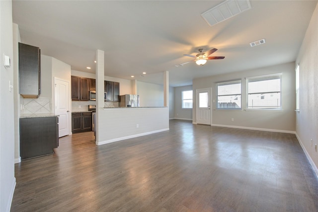 unfurnished living room with dark hardwood / wood-style flooring and ceiling fan