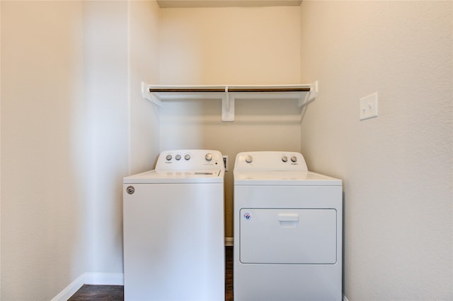 clothes washing area featuring dark hardwood / wood-style flooring and washer and clothes dryer