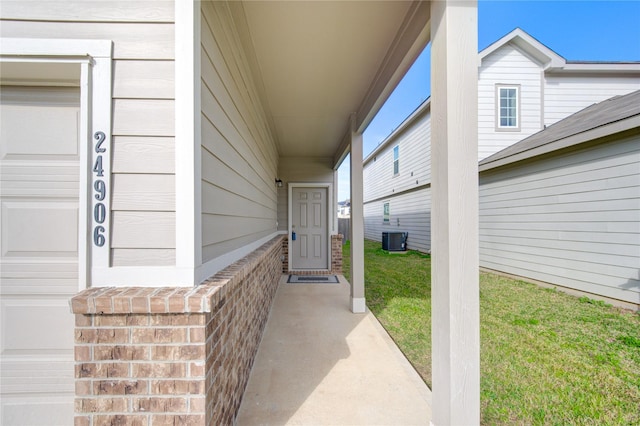 entrance to property featuring a yard and cooling unit