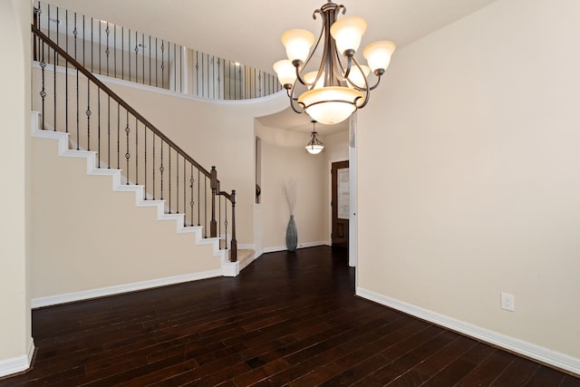 entrance foyer with dark hardwood / wood-style flooring and a notable chandelier