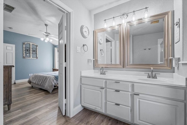 bathroom featuring ceiling fan, hardwood / wood-style floors, vanity, and a textured ceiling