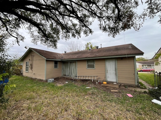 rear view of house featuring a yard