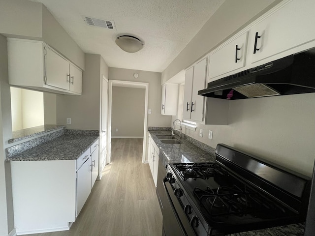 kitchen with black gas range, white cabinetry, sink, light hardwood / wood-style flooring, and a textured ceiling