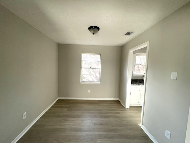 spare room featuring dark hardwood / wood-style flooring and a textured ceiling