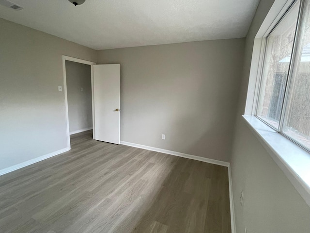 spare room featuring a textured ceiling and hardwood / wood-style flooring