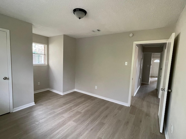 spare room featuring wood-type flooring and a textured ceiling