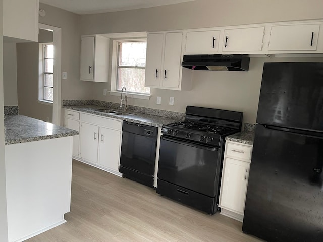 kitchen featuring black appliances, white cabinets, light wood-type flooring, and sink