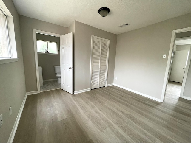 unfurnished bedroom with light hardwood / wood-style floors and a textured ceiling