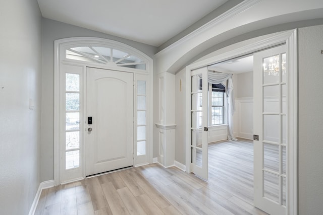 foyer with light hardwood / wood-style flooring and a notable chandelier