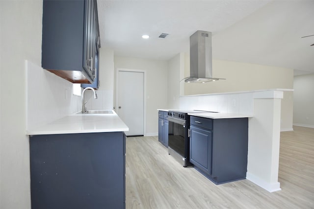 kitchen with sink, blue cabinetry, wall chimney range hood, light hardwood / wood-style flooring, and stainless steel range with electric cooktop