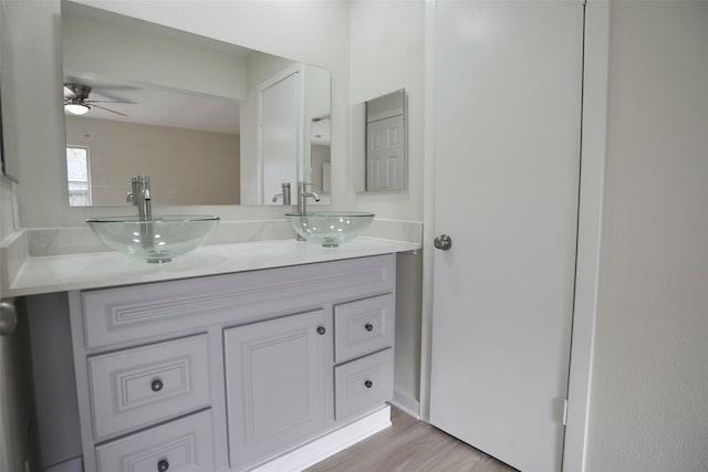 bathroom with hardwood / wood-style floors, vanity, and ceiling fan