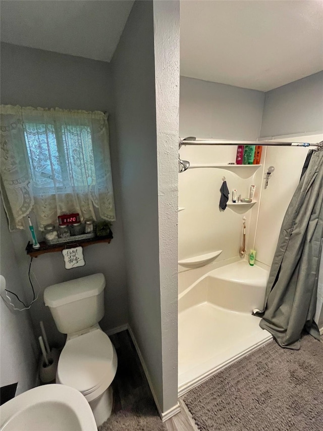 bathroom with toilet and walk in shower