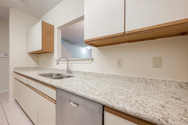 kitchen with dishwasher, sink, white cabinets, and light tile patterned floors