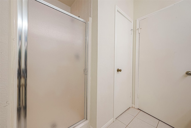 bathroom featuring tile patterned flooring and a shower with shower door