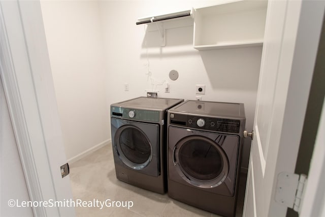 clothes washing area with light tile patterned floors and washing machine and dryer