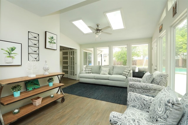 sunroom / solarium featuring lofted ceiling with skylight, a wealth of natural light, and ceiling fan