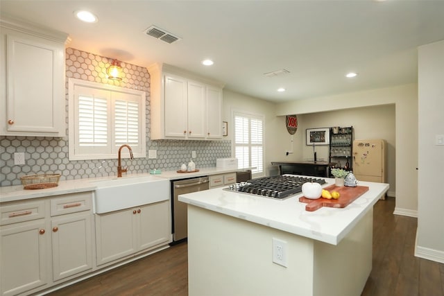 kitchen featuring white cabinetry, appliances with stainless steel finishes, a center island, and sink