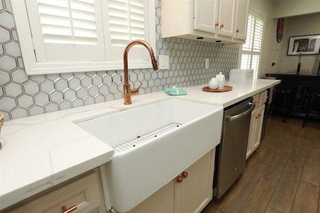 kitchen with dark wood-type flooring, sink, light stone counters, dishwasher, and backsplash