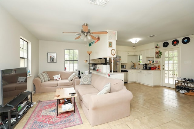 living room with ceiling fan, light tile patterned floors, and a wealth of natural light