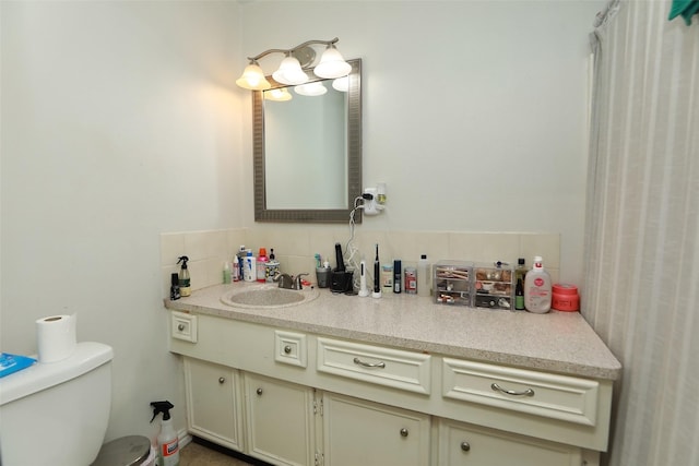 bathroom featuring tasteful backsplash, vanity, and toilet