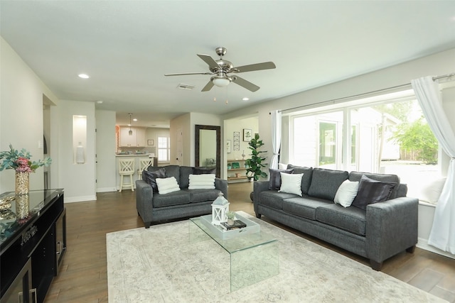 living room with ceiling fan and dark hardwood / wood-style flooring