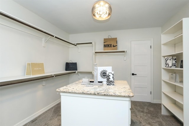 walk in closet with dark colored carpet