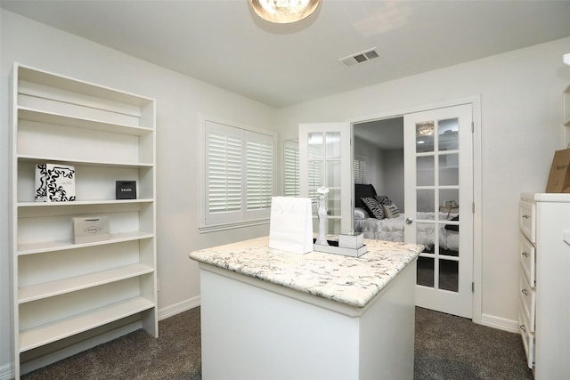 walk in closet featuring french doors and dark colored carpet