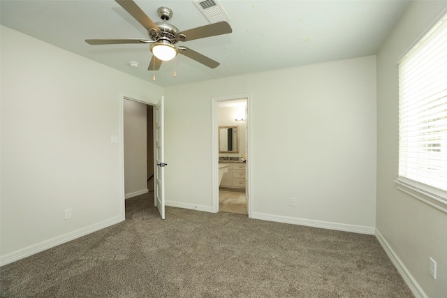 unfurnished bedroom with ceiling fan, ensuite bathroom, and carpet