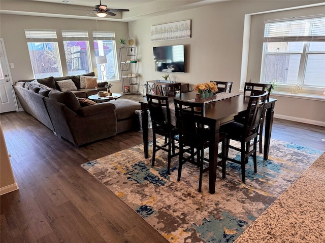 dining room featuring dark hardwood / wood-style flooring, ceiling fan, and a healthy amount of sunlight